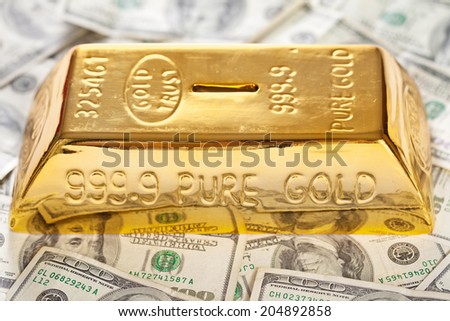 Closeup of golden bullion like moneybox on hundred dollars banknotes background