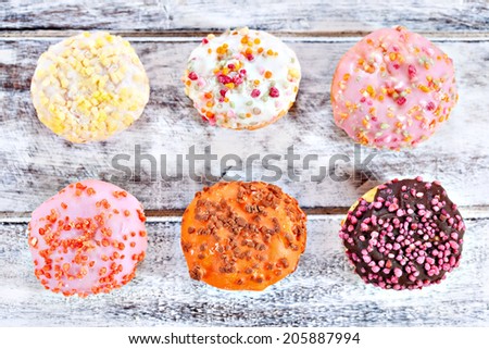 Mixed donuts with strawberry, chocolate, orange, lemon and vanilla flavor glaze on white wooden table background
