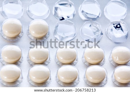 Open blister transparen pack of some round yellow pills or vitamins closeup
