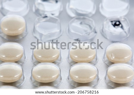 Open blister transparen pack of some round yellow pills or vitamins closeup