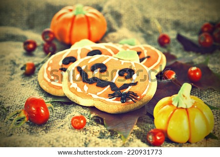 Stylized Halloween decor pumpkin cookies and assorted pumpkins. Popular American event party decorative dessert idea.