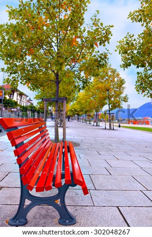 Red bench on neat and clean pedestrian sidewalk in Italy