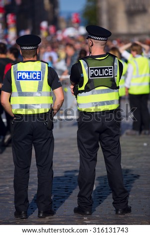 Two police officers in bright yellow vests on duty