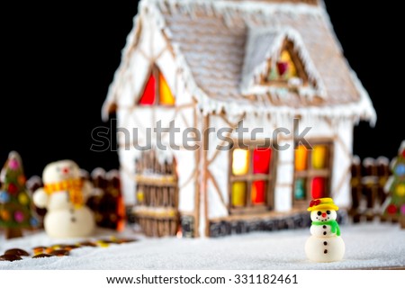 Decorative Christmas  gingerbread house with lights inside on black background