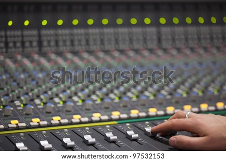 Someone is sliding Large Music Mixer\'s slider in recording studio. Closeup