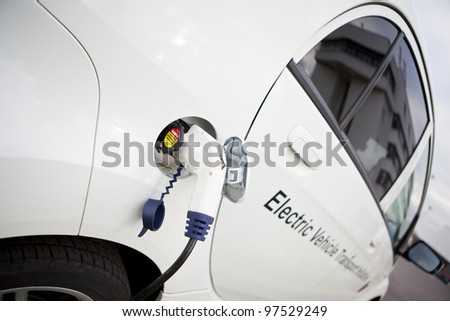 Cable hanging down from gas tank location on electrical vehicle. Outdoors