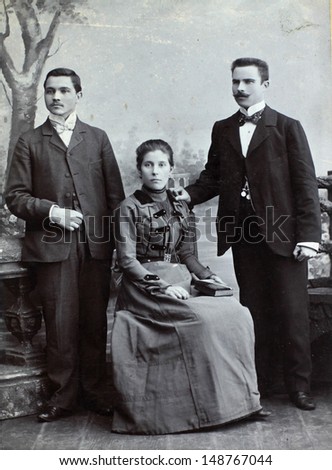 RUSSIAN EMPIRE - CIRCA 1910:Vintage photo shows three young friends wearing elegant clothing. Nostalgic picture. Circa 1910. Russian Empire, beginning of 20th century.