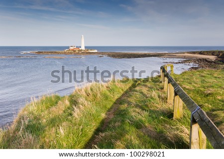 St Marys lighthouse from cliff top / St Marys Lighthouse with lead in fence from cliff tops