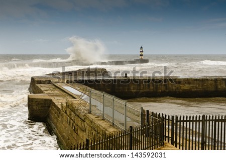 Seaham Harbour in rough seas / Crashing waves over the north pier in a rough sea at Seaham Harbour