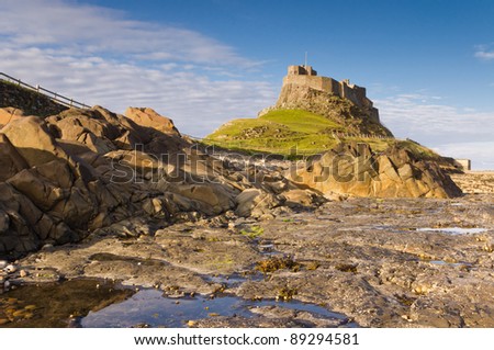 Lindisfarne Castle from the Rocks / Lindisfarne Castle viewed from low with rock pool in foreground