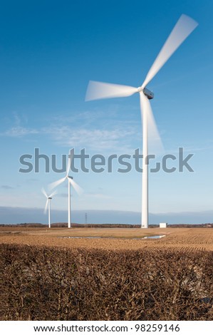 Wind turbines with motion blur vertical / Wind farm showing motion blur on rotating blades