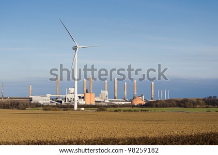 Wind turbine and factory / Modern wind turbine with old factory behind it