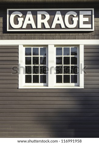 Garage sign on wooden wall with a window