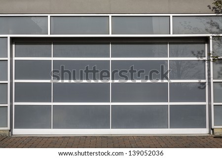 Access to a modern glass door panel garage