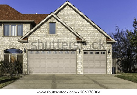Traditional three car wooden garage with driveway