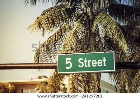 Coconut palm trees against 5 th Street sign in Miami Beach, Florida