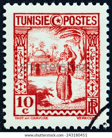 TUNISIA - CIRCA 1931: A stamp printed in Tunisia shows woman carrying water, circa 1931.