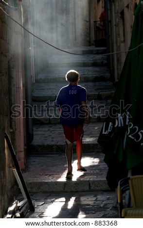 boy walking up a back street in Korcula, Croatia