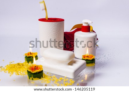 Toothbrushes, soap, liquid soap and red towel on white background.