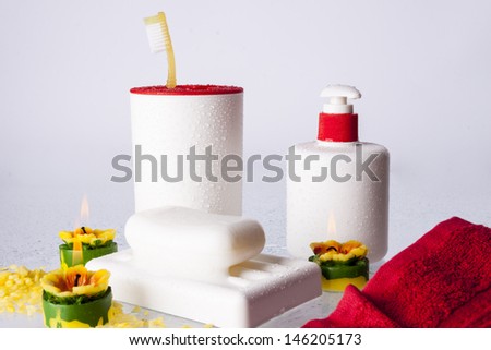 Toothbrushes, soap, liquid soap and red towel on white background.