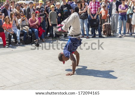PARIS, FRANCE -  APRIL 25:B-boy doing some breakdance moves in front a street crowd, at Arch of Triumph on april 25, 2013 in Paris. Its popular form of earnings in big cities.