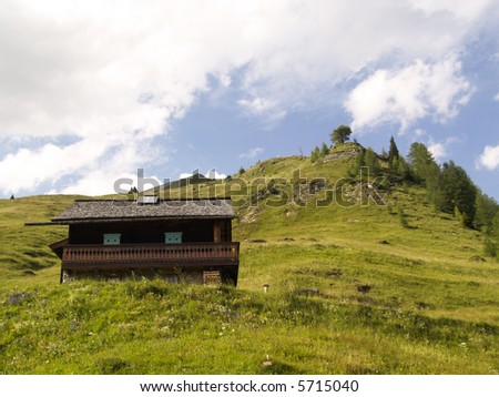 Small wooden cottage in mountains. Summer time