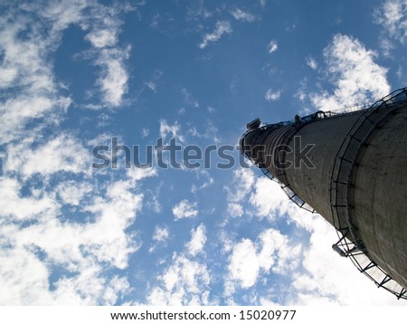 Industrial big chimney in background blue sky white clouds