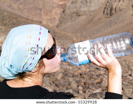 Woman in Atlas mountain in Morocco drinking water.