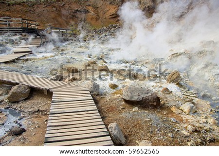 Wooden path in geothermal area in Iceland. Summer day.