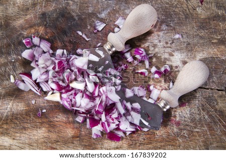 Preparation of the red onion minced above a wood base with the crescent