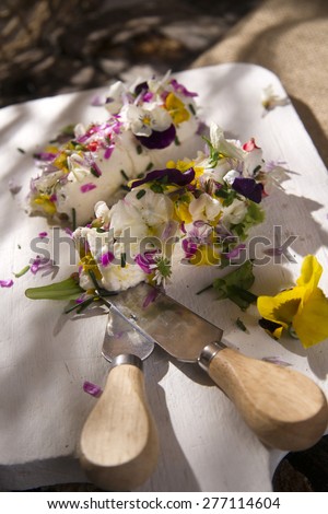 Presentation of goat cheese rolls with edible flowers