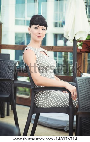retro portrait of vintage beautiful woman in cafe.Retro style. Stylish rich slim girl in vintage dress and makeup with dark hair. alluring lady at vacation at luxury villa.Audrey Hepburn style.series