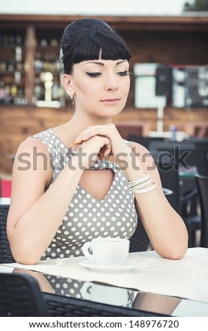 vintage beautiful woman in restaurant cafe with coffee.Breakfast time.Stylish rich slim girl in retro dress.glamorous lady at vacation. Retro style.Audrey Hepburn style.series