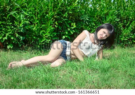 Happy vacation woman summer girl smiling and resting on nature. Beautiful woman outdoors. Sexy summer girl. Trendy summer woman lying on green grass in park