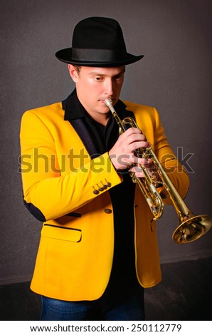 Handsome musician trumpet player playing trumpet at studio. Jazz-band