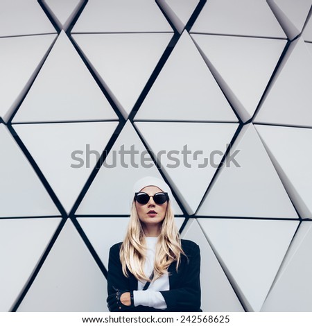 Glamorous blonde standing at the wall. Urban fashion black and white  style