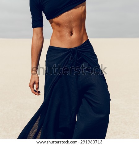Slim Female body on the background desert in black clothes