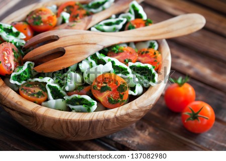 Cherry tomatoes with gluten-free pasta and spinach sauce, selective focus