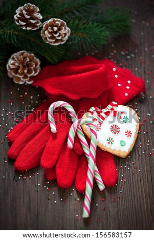 Red knitted gloves, Christmas candy canes and cookies, selective focus
