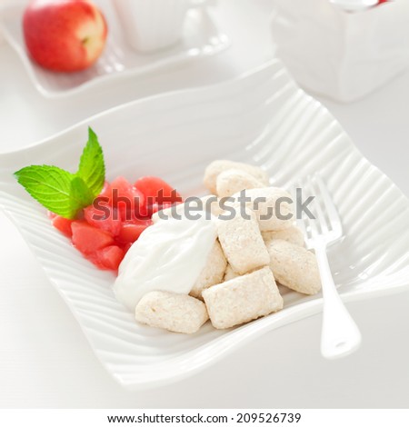 Cottage cheese gnocchi with peach jam and sour cream, selective focus