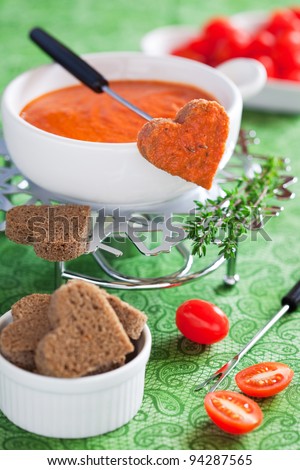 Fondue with tomatoes and shape heart bread, selective focus