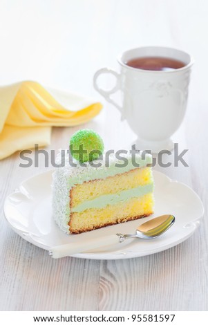 Saffron sponge cake with cream green tea, slice on a plate, selective focus