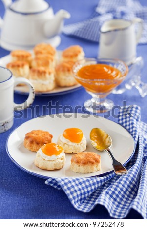 Scones with peach jam and whipped cream for breakfast, selective focus