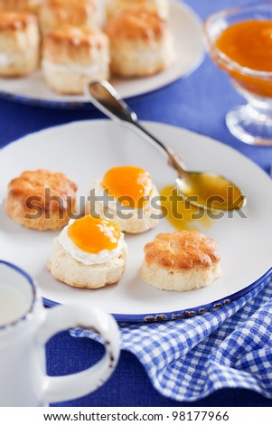 Scones with peach jam and whipped cream for breakfast, selective focus