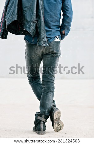Attractive young man in back with smartphone in his pocket