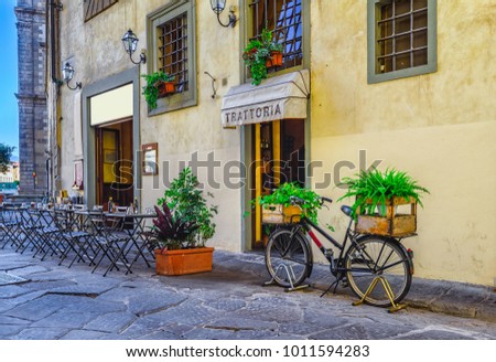 Narrow street with tables of old trattoria in Florence, Tuscany, Italy. Architecture and landmark of Florence. Cozy cityscape of Florence