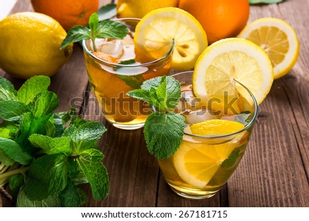 Lemonade with fresh lemon and mint on wooden background