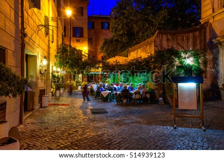 Old cozy street at night in Trastevere, Rome, Italy. Trastevere is rione of Rome, on the west bank of the Tiber in Rome, Lazio, Italy.  Architecture and landmark of Rome. Nightlife of Rome.