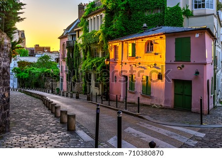 Sunset view of old street in quarter Montmartre in Paris, France. Cozy cityscape of Paris. Architecture and landmarks of Paris
