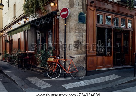 Cozy street with tables of cafe and old bicycle in Paris, France. Architecture and landmarks of Paris. Postcard of Paris